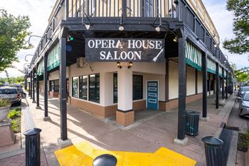 A white building with a black awning that says Opera House Saloon.